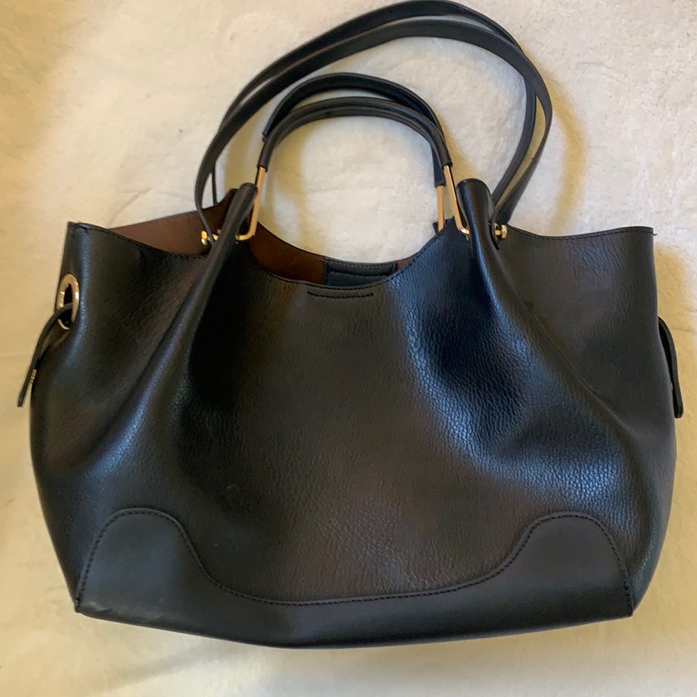 Stylish Black tote with brass accents on sides and handle.